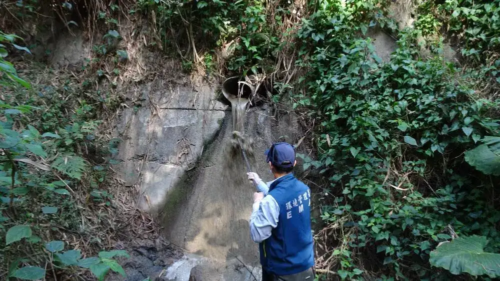 督察人員涉水橫渡二仁溪進行採集廢水